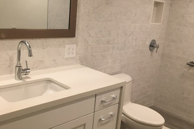 Bathroom - mid-sized transitional 3/4 white tile and porcelain tile porcelain tile and gray floor bathroom idea in Hawaii with shaker cabinets, white cabinets, white walls, an undermount sink and quartz countertops