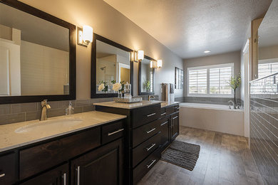 Example of a mid-sized transitional master gray tile and subway tile dark wood floor and brown floor alcove shower design in Salt Lake City with dark wood cabinets, quartzite countertops, raised-panel cabinets, an undermount tub, beige walls, an undermount sink and a hinged shower door