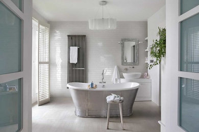 Inspiration for a traditional ensuite bathroom in Berkshire with white cabinets, a freestanding bath, metro tiles, white walls, a vessel sink, shaker cabinets and beige floors.