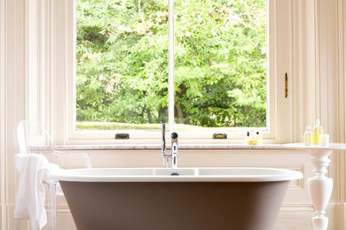 Ejemplo de cuarto de baño clásico con bañera exenta y suelo de madera en tonos medios
