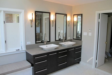 Example of a large trendy master marble floor and white floor bathroom design in DC Metro with flat-panel cabinets, dark wood cabinets, beige walls, a vessel sink and quartz countertops