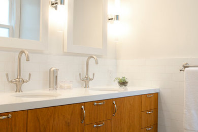 サンフランシスコにあるコンテンポラリースタイルのおしゃれな浴室 (アンダーカウンター洗面器、フラットパネル扉のキャビネット、中間色木目調キャビネット、白いタイル、サブウェイタイル、白い壁) の写真