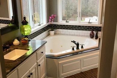Inspiration for a large contemporary master black and white tile corner bathtub remodel in Minneapolis with raised-panel cabinets, white cabinets and marble countertops