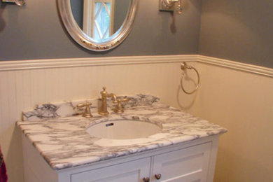 Modelo de cuarto de baño pequeño con lavabo bajoencimera, armarios estilo shaker, puertas de armario blancas, paredes grises y aseo y ducha