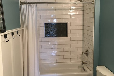 Example of a mid-sized mountain style kids' white tile and subway tile mosaic tile floor and white floor bathroom design in DC Metro with furniture-like cabinets, medium tone wood cabinets, a two-piece toilet, blue walls, an undermount sink, solid surface countertops and white countertops