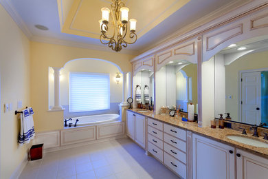 Inspiration for a large timeless master white tile and porcelain tile porcelain tile bathroom remodel in Richmond with raised-panel cabinets, white cabinets, a two-piece toilet, yellow walls, granite countertops and an undermount sink