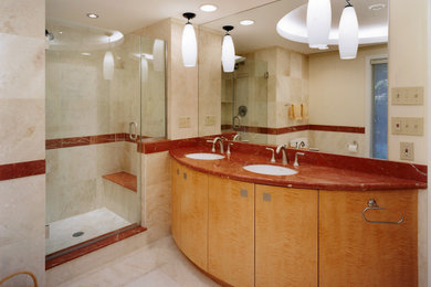 ワシントンD.C.にあるモダンスタイルのおしゃれなマスターバスルーム (フラットパネル扉のキャビネット、アルコーブ型シャワー、ベージュのタイル、大理石の洗面台、赤い洗面カウンター、洗面台2つ) の写真
