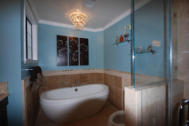 Modelo de cuarto de baño principal clásico de tamaño medio con bañera exenta, baldosas y/o azulejos beige, baldosas y/o azulejos de porcelana, paredes azules y suelo de piedra caliza