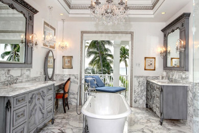 Inspiration for a large timeless master white tile and marble tile marble floor and white floor freestanding bathtub remodel in Miami with gray cabinets, a two-piece toilet, white walls, a drop-in sink and marble countertops