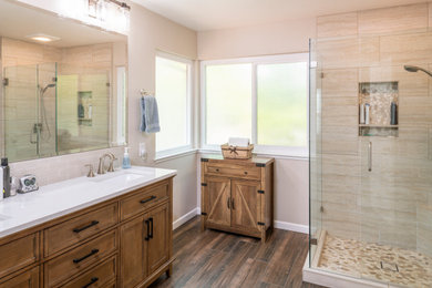 Example of a minimalist master beige tile and porcelain tile porcelain tile, brown floor and double-sink bathroom design in Sacramento with dark wood cabinets, beige walls, an undermount sink, marble countertops, a hinged shower door, white countertops and a freestanding vanity