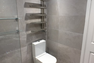 Ejemplo de cuarto de baño infantil contemporáneo de tamaño medio con sanitario de dos piezas, paredes grises, suelo de baldosas de porcelana y suelo gris