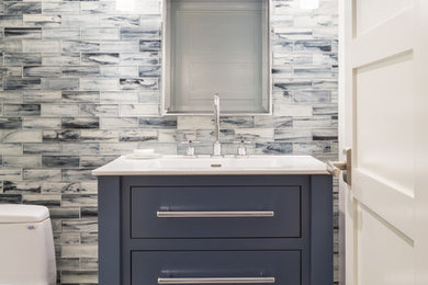 Bathroom - mid-sized contemporary 3/4 blue tile and stone tile porcelain tile bathroom idea in Providence with flat-panel cabinets, blue cabinets, a one-piece toilet, blue walls, a drop-in sink and solid surface countertops