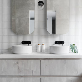 Inspiration för mellanstora moderna vitt en-suite badrum, med vit kakel, keramikplattor, vita väggar, ett fristående handfat, släta luckor, klinkergolv i porslin, bänkskiva i kvarts, grått golv och grå skåp