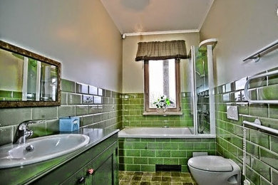 他の地域にある小さなおしゃれなマスターバスルーム (コンソール型シンク、シャワー付き浴槽	、緑のタイル、緑の壁) の写真