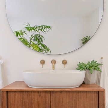 Bathroom basin with vintage dresser and round mirror
