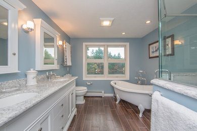 Foto de cuarto de baño principal clásico con lavabo bajoencimera, armarios tipo mueble, puertas de armario blancas, ducha esquinera y paredes azules