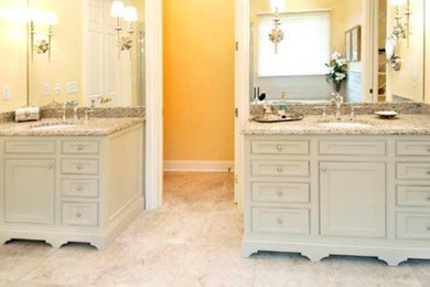 Ejemplo de cuarto de baño principal clásico con lavabo bajoencimera, armarios con paneles empotrados, puertas de armario blancas y paredes amarillas