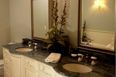 Example of a master beige tile bathroom design in Other with an undermount sink, furniture-like cabinets, white cabinets, granite countertops, a one-piece toilet and beige walls