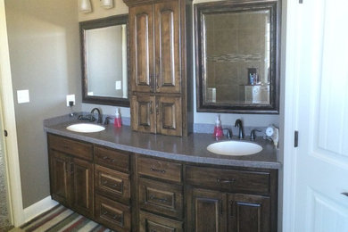 Example of a mid-sized classic master bathroom design in Other with recessed-panel cabinets, medium tone wood cabinets, solid surface countertops and beige walls