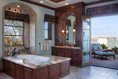 サンディエゴにある高級な広いトラディショナルスタイルのおしゃれなマスターバスルーム (レイズドパネル扉のキャビネット、濃色木目調キャビネット、アンダーマウント型浴槽、セラミックタイル、青い壁、セラミックタイルの床、アンダーカウンター洗面器、大理石の洗面台、ベージュのタイル、アルコーブ型シャワー) の写真
