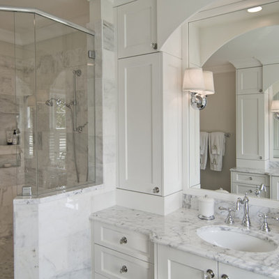 Corner shower - traditional white tile corner shower idea in Charlotte with an undermount sink, recessed-panel cabinets and white cabinets