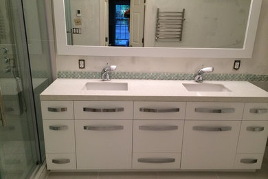 Example of a mid-sized trendy 3/4 stone slab ceramic tile bathroom design in Atlanta with flat-panel cabinets, white cabinets, a one-piece toilet, beige walls, a drop-in sink and solid surface countertops
