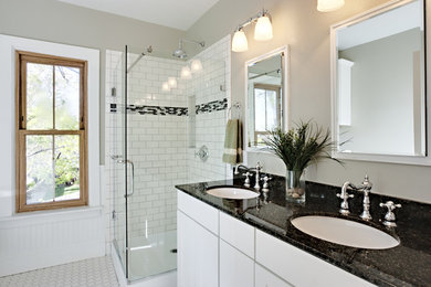 Example of an urban master white tile and subway tile ceramic tile and white floor corner shower design in Miami with flat-panel cabinets, white cabinets, beige walls, an undermount sink, granite countertops and a hinged shower door