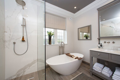 Photo of a traditional ensuite bathroom in Other with a freestanding bath, a walk-in shower, beige walls, medium hardwood flooring, a submerged sink and an open shower.