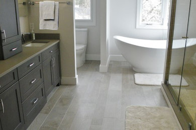 Exempel på ett modernt en-suite badrum, med ett fristående badkar, en dubbeldusch, en toalettstol med hel cisternkåpa, grå väggar, klinkergolv i keramik, ett undermonterad handfat, skåp i shakerstil, skåp i mörkt trä, grå kakel, keramikplattor och bänkskiva i kvartsit