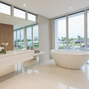 Trendy gray tile freestanding bathtub photo in Miami with an undermount sink, flat-panel cabinets and white cabinets