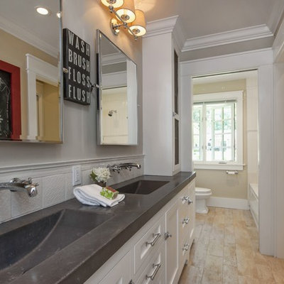 Elegant beige tile and white tile bathroom photo in San Francisco with an integrated sink, white cabinets and concrete countertops