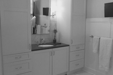 Foto de cuarto de baño principal tradicional grande con armarios estilo shaker, puertas de armario blancas, paredes blancas, suelo de mármol, lavabo bajoencimera, encimera de acrílico, baldosas y/o azulejos blancos, baldosas y/o azulejos de mármol y suelo blanco