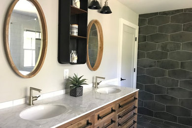 Diseño de cuarto de baño minimalista con puertas de armario de madera oscura, bañera exenta y baldosas y/o azulejos blancas y negros