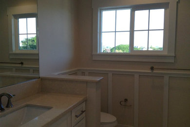 Photo of a large bathroom in Hawaii with a built-in sink, a one-piece toilet, beige tiles and beige walls.