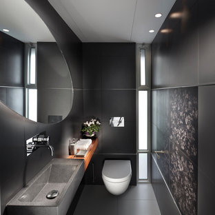 Esempio di una stanza da bagno design con WC sospeso, pareti nere e lavabo integrato