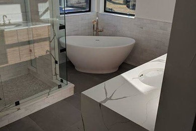 Mid-sized transitional master gray tile and marble tile porcelain tile and gray floor bathroom photo in Denver with recessed-panel cabinets, white cabinets, a two-piece toilet, white walls, an undermount sink, quartz countertops, a hinged shower door and white countertops