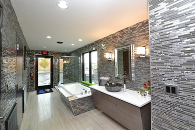 Exemple d'une grande salle de bain principale industrielle en bois foncé avec une vasque, un placard à porte plane, une baignoire posée, une douche d'angle, un carrelage gris, des carreaux en allumettes et un mur gris.