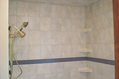 Example of a mid-sized master beige tile and stone tile doorless shower design in Raleigh