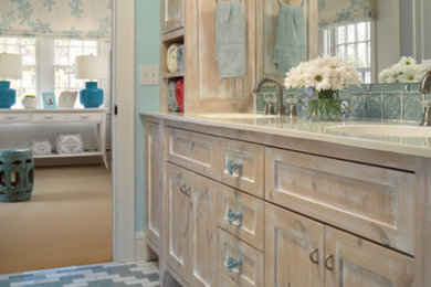 Modelo de cuarto de baño costero grande con armarios estilo shaker, puertas de armario con efecto envejecido, paredes azules, suelo con mosaicos de baldosas, lavabo integrado, encimera de acrílico y suelo multicolor