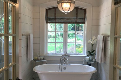 Imagen de cuarto de baño principal clásico grande con bañera exenta, paredes beige, suelo de baldosas de cerámica y suelo blanco