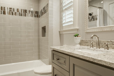 Пример оригинального дизайна: ванная комната среднего размера в стиле неоклассика (современная классика) с фасадами с выступающей филенкой, серыми фасадами, ванной в нише, душем над ванной, унитазом-моноблоком, бежевой плиткой, керамической плиткой, бежевыми стенами, душевой кабиной, врезной раковиной, столешницей из кварцита и шторкой для ванной