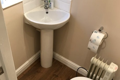 Diseño de cuarto de baño principal actual pequeño con paredes beige, lavabo con pedestal y suelo marrón