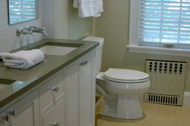 Bild på ett mellanstort vintage badrum för barn, med ett undermonterad handfat, skåp i shakerstil, vita skåp, bänkskiva i kvartsit, ett badkar i en alkov, en dusch/badkar-kombination, en toalettstol med separat cisternkåpa, vit kakel, porslinskakel, gröna väggar och klinkergolv i porslin