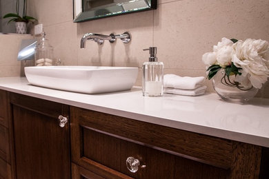 Exemple d'une salle de bain principale tendance en bois foncé avec une vasque, un placard à porte shaker, un plan de toilette en quartz modifié, une douche ouverte, un carrelage beige, des carreaux de porcelaine, un mur beige et un sol en carrelage de porcelaine.