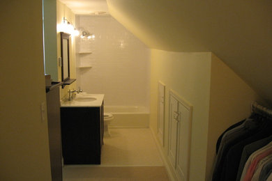 Aménagement d'une petite salle d'eau classique avec un placard à porte shaker, des portes de placard marrons, une baignoire en alcôve, un combiné douche/baignoire, WC séparés, un carrelage blanc, un carrelage métro, un mur orange, un sol en carrelage de céramique, un lavabo encastré et un plan de toilette en granite.