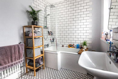 This is an example of a medium sized modern family bathroom in Cardiff with a corner bath, a corner shower, white tiles, ceramic tiles, purple walls, ceramic flooring, a pedestal sink, multi-coloured floors and a hinged door.