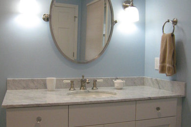 Esempio di una stanza da bagno con doccia tradizionale di medie dimensioni con lavabo sottopiano, ante in stile shaker, ante bianche, top in marmo e pareti blu