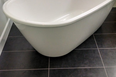 Minimalist slate floor freestanding bathtub photo in Other with white walls