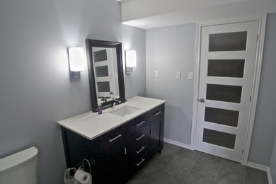 Example of a mid-sized minimalist ceramic tile bathroom design in Toronto with flat-panel cabinets, dark wood cabinets and granite countertops