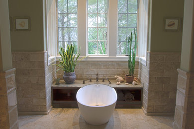 Cette image montre une salle de bain traditionnelle avec une baignoire indépendante et un carrelage beige.